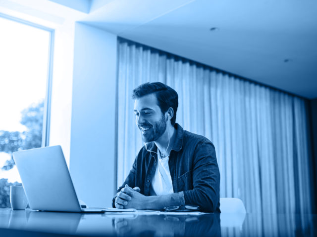 man in front of his laptop speaking to someone on a virtual call