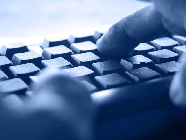 blue banner hands typing on a keyboard