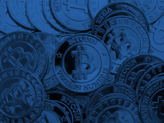 An image of Bitcoin as physical coins with a blue layer over it.